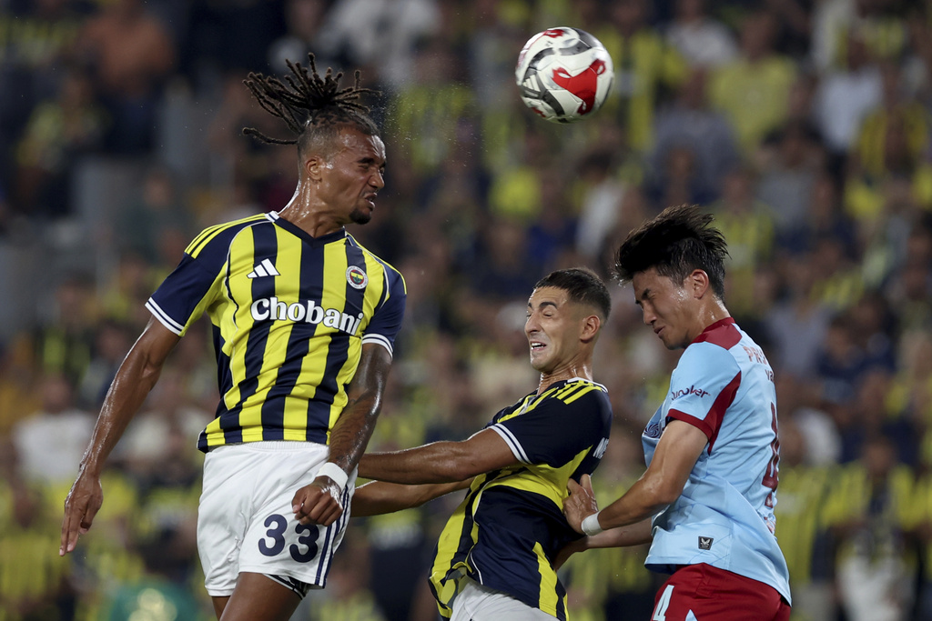 Fenerbahce's Archie Brown, left, heads the ball against Feyenoord's Tsuyoshi Watanabe, right, during a Champions League third qualifying round second leg soccer match between Fenerbahce and Feyenoord at the Ulker stadium, in Istanbul, Turkey, Tuesday, Aug. 12, 2025. (Huseyin Yavuz/Dia Photo via AP)