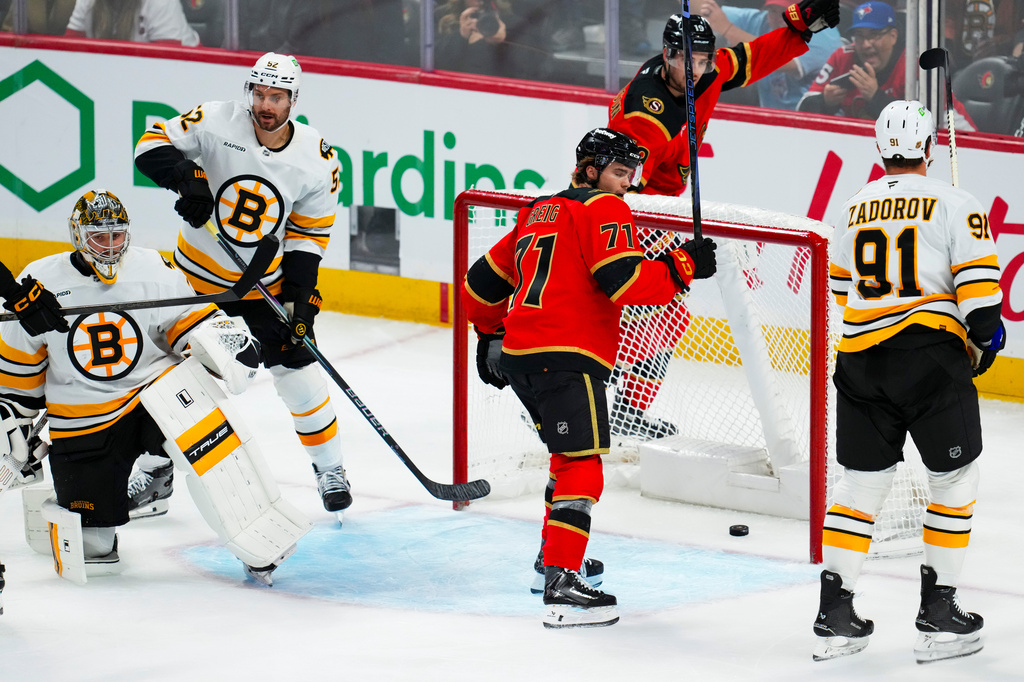 Ottawa Senators' Ridly Greig (71) and Drake Batherson (19) react after a goal by teammate Tim Stützle (not shown) against Boston Bruins goaltender Jeremy Swayman, left, during third-period NHL hockey game action in Ottawa, Ontario, Monday, Oct. 27, 2025. (Sean Kilpatrick/The Canadian Press via AP)