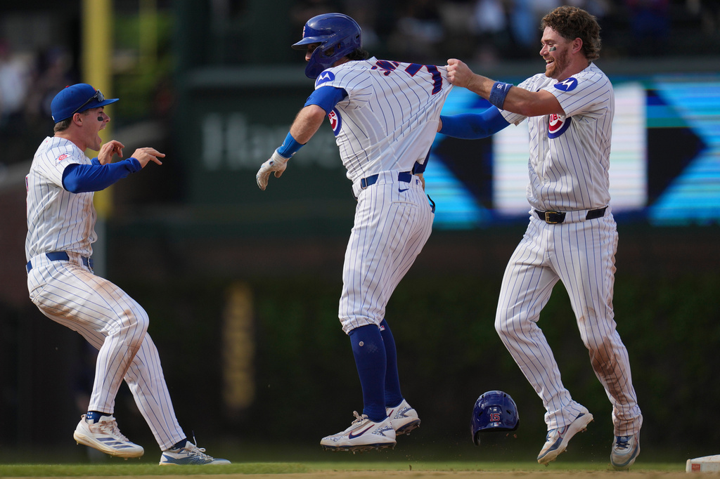 Chicago Cubs' Dansby Swanson, center, celebrates with Carson Kelly, right, and Matt Shaw after driving in the game-winning run in the 10th inning of a baseball game against the Philadelphia Phillies, Thursday, April 23, 2026, in Chicago. (AP Photo/Erin Hooley)