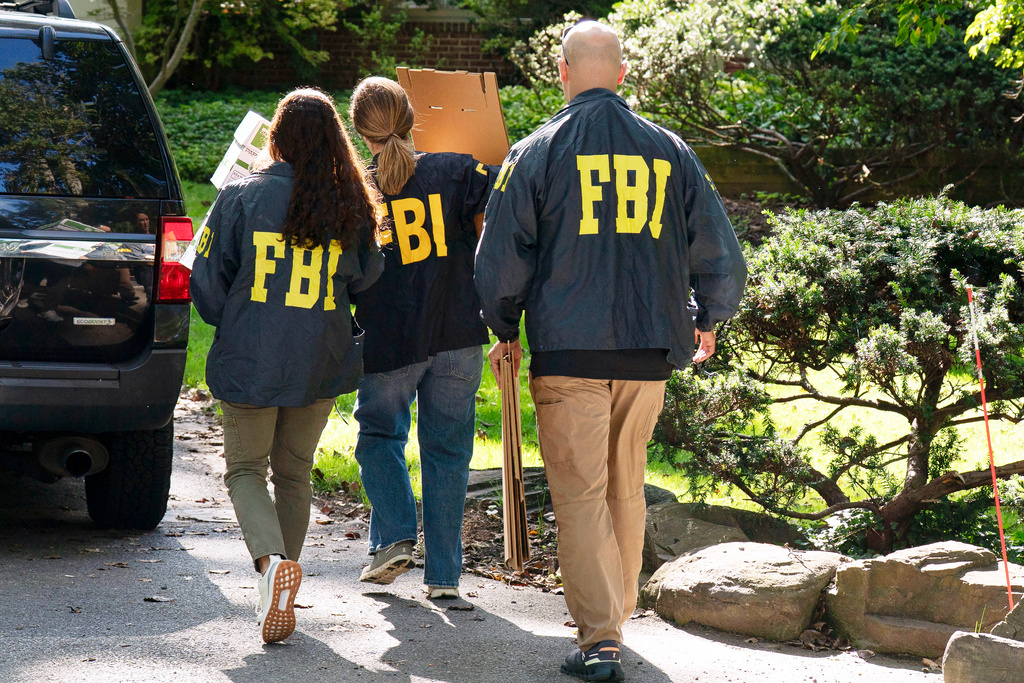 FBI agents carry empty boxes to former national security adviser John Bolton's house, Friday, August. 22, 2025, in Bethesda, Md. (AP Photo/Jose Luis Magana)