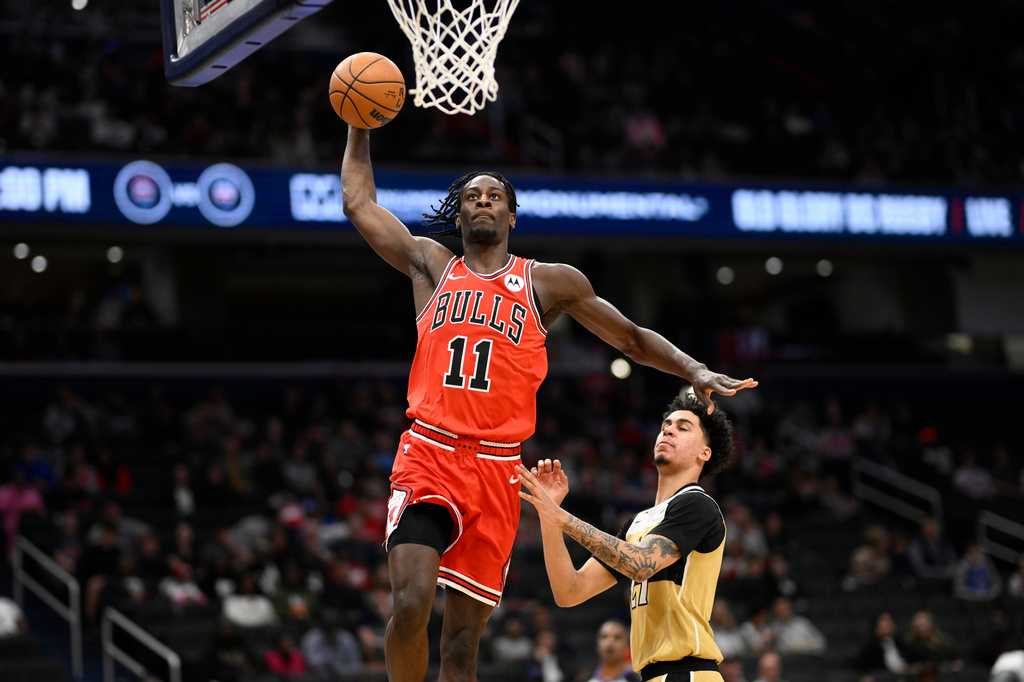 Chicago Bulls forward Leonard Miller (11) goes to the basket past Washington Wizards guard Will Riley, right, during the first half of an NBA basketball game, Thursday, April 9, 2026, in Washington. (AP Photo/Nick Wass)