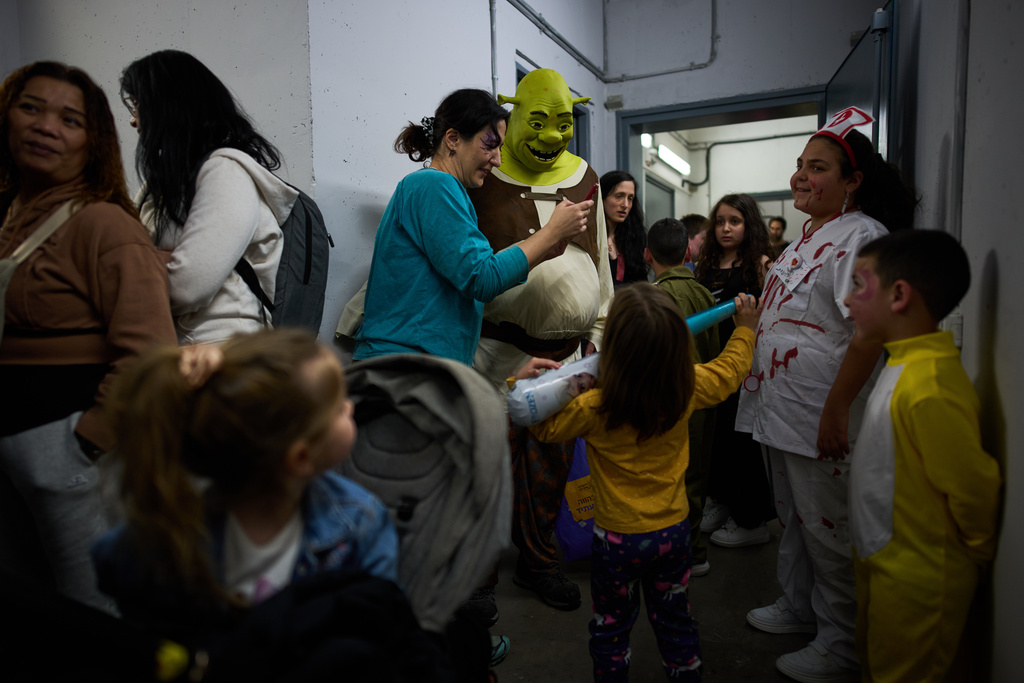 People, some wearing costumes, celebrate the Jewish holiday of Purim in an underground metro station used as a shelter against possible Iranian missile attacks, in Ramat Gan, Israel, Monday, March 2, 2026. (AP Photo/Oded Balilty)