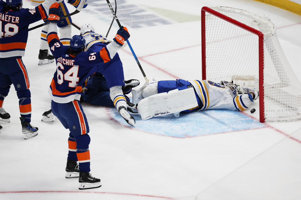 New York Islanders players celebrate after the puck gets past Buffalo Sabres goaltender Alex Lyon (34) but was later ruled not a goal during the first period of an NHL hockey game, Saturday, Jan. 24, 2026, in Elmont, N.Y. (AP Photo/Heather Khalifa)