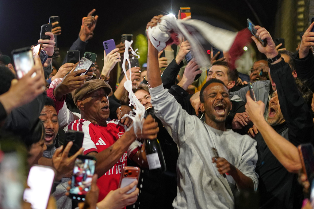 Former Arsenal player Ian Wright celebrates with Arsenal supporters at the Arsenal stadium after Arsenal's soccer team won the Premier League title in London, Tuesday, May 19, 2026.(AP Photo/Alberto Pezzali)