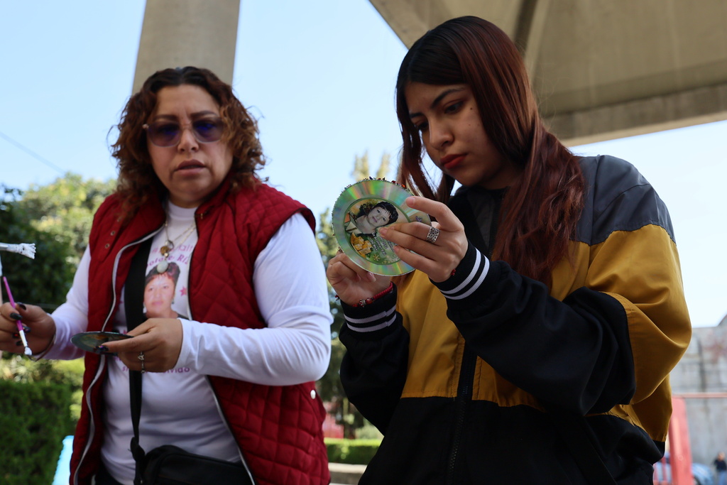 Marisol Rizo, left, who said her mother Maria Dolores Rizo Juarez went missing on Dec. 22, 2012 in Alcoman, state of Mexico, and her daughter Leslie Mendez, decorate Christmas ornaments with her photograph to hang on the Tree of Hope during an event organized by the diocese of Ecatepec at the Church of the Sacred Heart of San Cristobal in Ecatepec, State of Mexico, Monday, Nov. 17, 2025. (AP Photo/Ginnette Riquelme)