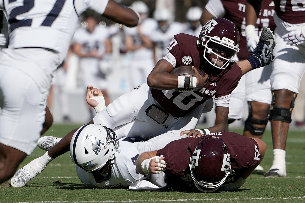 Texas A&M quarterback Marcel Reed (10) stretches out for more yards over Samford defensive lineman Donovan Grayson (88) after a short scramble during the first quarter of an NCAA college football game, Saturday, Nov. 22, 2025, in College Station, Texas. (AP Photo/Sam Craft)