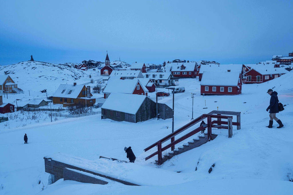 People walk in downtown of Nuuk, Greenland, on Tuesday, Jan. 13, 2026. (AP Photo/Evgeniy Maloletka)