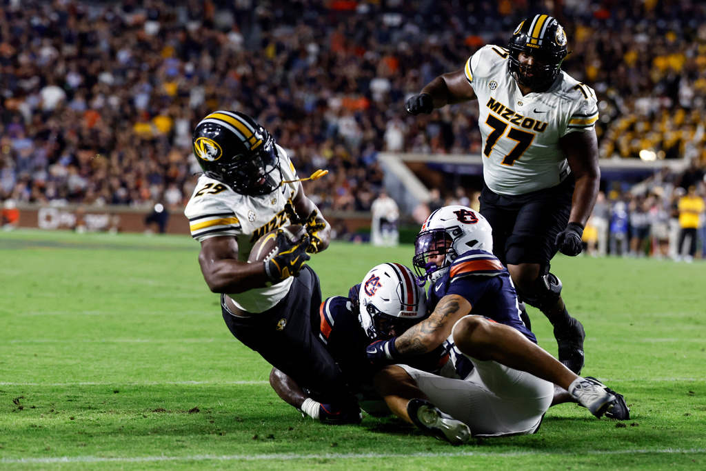 Missouri running back Ahmad Hardy (29) carries the ball in for a touchdown to tie the game as Auburn linebacker Robert Woodyard Jr. (0) and safety Eric Winters (25) defend during the second half of an NCAA college football game, Saturday, Oct. 18, 2025, in Auburn, Ala. (AP Photo/Butch Dill)