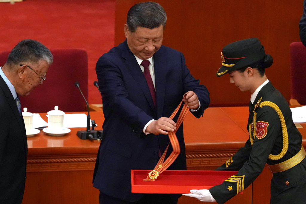 Chinese President Xi Jinping, center, prepares to award the July 1 medal to a recipient during a ceremony to mark the 105th anniversary of the founding of the Chinese Communist Party at the Great Hall of the People in Beijing, Wednesday, July 1, 2026. (AP Photo/Ng Han Guan)