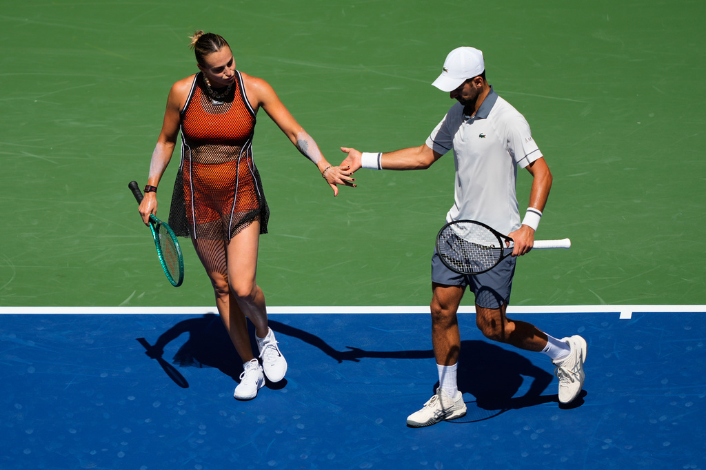 Aryna Sabalenka, of Belarus, and Novak Djokovic, of Serbia, high-five during a mixed doubles match at the U.S. Open tennis championships, Tuesday, Aug. 25, 2026, in New York. (AP Photo/Yuki Iwamura)