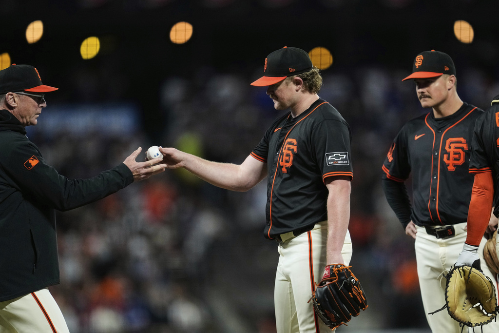 San Francisco Giants pitcher Logan Webb, center, hands the ball over to manager Bob Melvin, left, as he exits during the fifth inning of a baseball game against the Los Angeles Dodgers, Saturday, Sept. 13, 2025, in San Francisco. (AP Photo/Godofredo A. Vásquez)