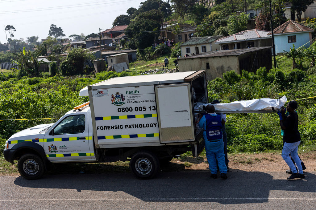 Police officers load a body into a forensic pathology vehicle at the scene of a mass shooting in KwaMakhutha township south of the city of Durban, South Africa, Wednesday, Sept. 23, 2026. (AP Photo)