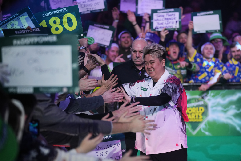 Leung Man Lok of Hong Kong arrives as he takes part in a round one match at the World Darts Championships, at Alexandra Palace in London, Friday, Dec. 12, 2025. (AP Photo/Kin Cheung)