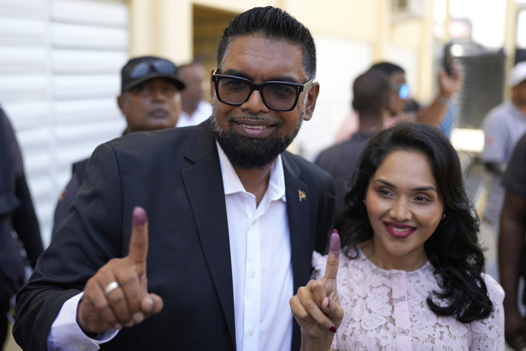 President Irfaan Ali, seeking another term, and his wife Arya Ali show their inked fingers after voting during general elections in Leonora, Guyana, Monday, Sept. 1, 2025. (AP Photo/Matias Delacroix)