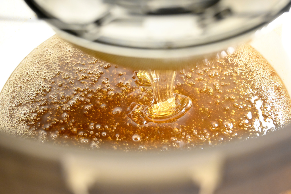 Honey is poured into a bucket in the Zografou suburb of Athens, Greece, July 1, 2025. (AP Photo/Michael Varaklas)