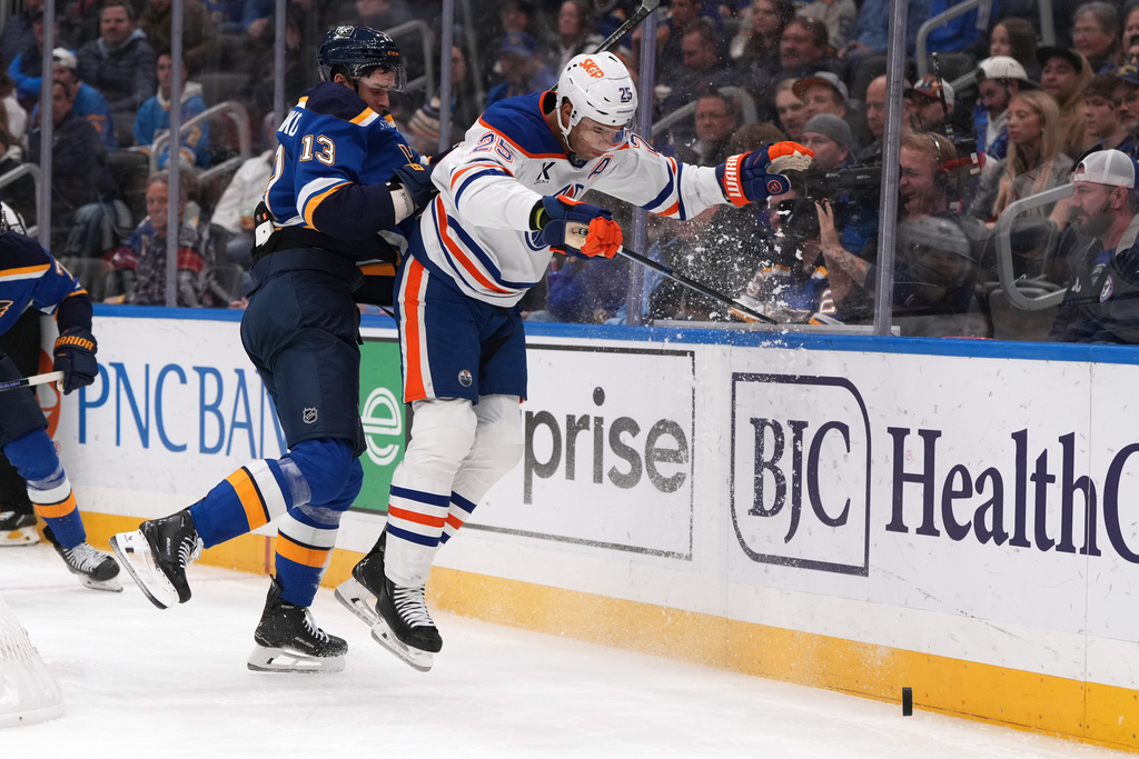 St. Louis Blues' Alexey Toropchenko (13) and Edmonton Oilers' Darnell Nurse (25) collide along the boards during the second period of an NHL hockey game Monday, Nov. 3, 2025, in St. Louis. (AP Photo/Jeff Roberson)