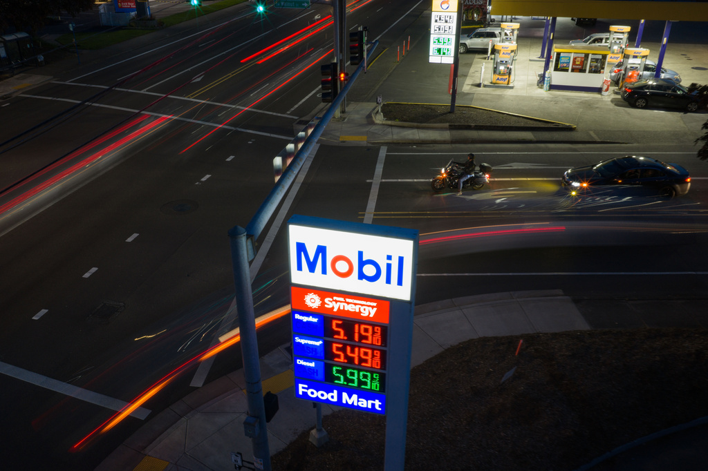 In this photo taken with a slow shutter speed, traffic moves past a sign for a Mobil gas station on Wednesday, April 29, 2026, in Portland, Ore. (AP Photo/Jenny Kane)