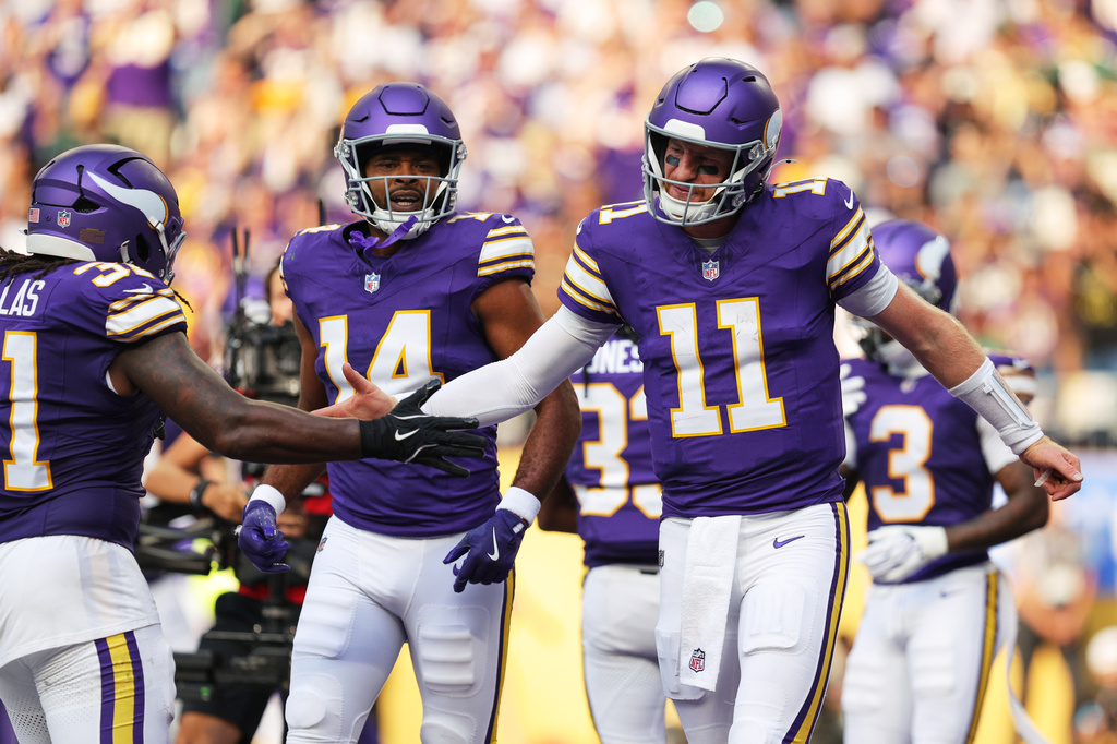 Minnesota Vikings' Carson Wentz (11), Nick Niemann, left, and Jauan Jennings (14) celebrate a touchdown during the first half of an NFL football game against the Green Bay Packers, Sunday, Sept. 13, 2026, in Minneapolis, Minn. (AP Photo/Bailey Hillesheim)