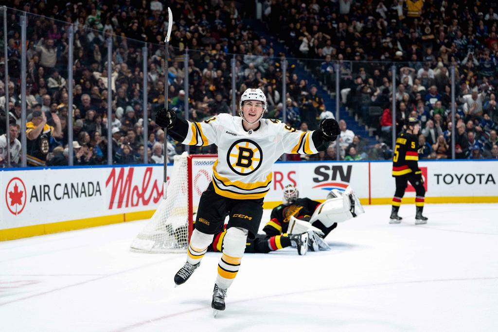 Boston Bruins' Fraser Minten (93) celebrates his game-winning goal against the Vancouver Canucks as Canucks goaltender Kevin Lankinen (32) lays on the ice and Tom Willander (5) skates away during overtime in an NHL hockey game in Vancouver, British Columbia, on Saturday, Jan. 3, 2026. (Ethan Cairns/The Canadian Press via AP)