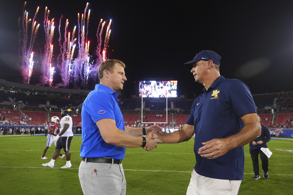 SMU head coach Rhett Lashlee, left, shakes hands with East Texas A&M head coach Clint Dolezel after the second half of an NCAA college football game Saturday, Aug. 30, 2025, in Dallas. (AP Photo/LM Otero)