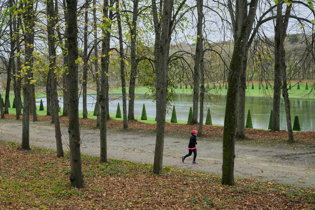 FILE - A woman jogs at the Marly le Roi garden west of Paris, Nov. 14, 2025. (AP Photo/Michel Euler, File)