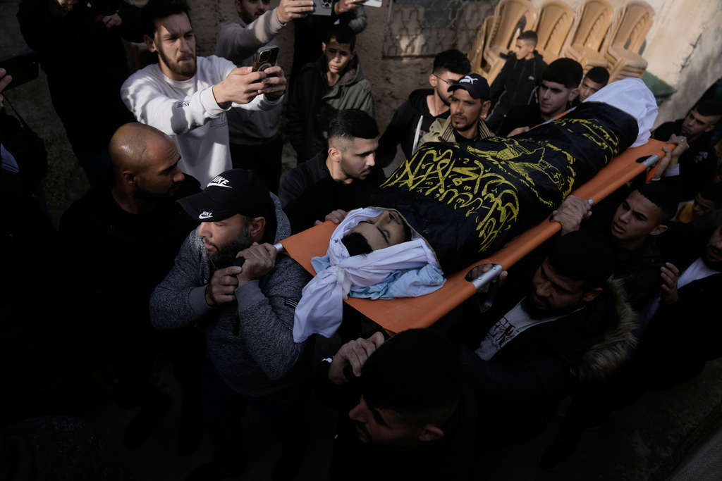 Palestinian men carry Ahmad Ziyoud, draped in the flag of the Islamic Jihad militant group, during his funeral in Silat al-Harithiya, near Jenin, in the West Bank, Sunday, Dec. 21, 2025. (AP Photo/Majdi Mohammad)