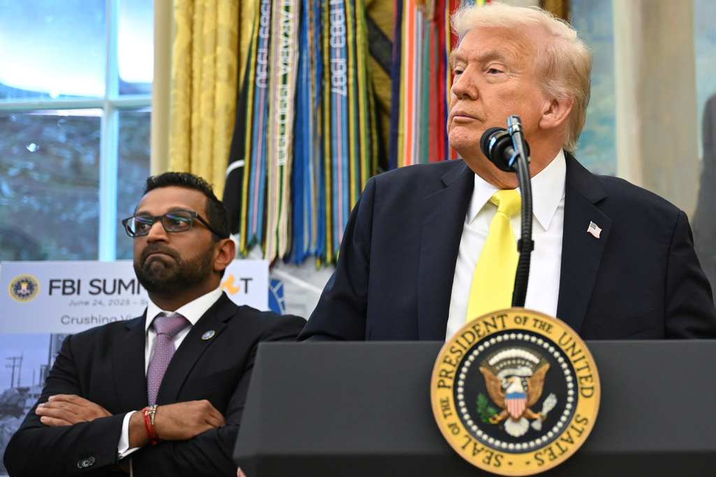 President Donald Trump listens to a question from a reporter during an event in the Oval Office at the White House, Wednesday, Oct. 15, 2025, in Washington, as FBI director Kash Patel listens. (AP Photo/John McDonnell)