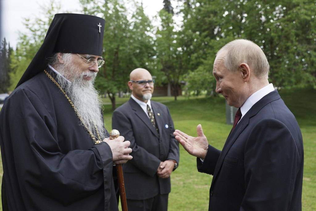 Russia's President Vladimir Putin, right, and Alexei (John Trader), Archbishop of the Orthodox Church in America Diocese of Alaska talk after laying flowers to the graves of Soviet soldiers who died during World War II at Fort Richardson National Cemetery, Alaska, Friday, Aug. 15, 2025, after meeting with U.S. President Donald Trump. (Gavriil Grigorov, Sputnik, Kremlin Pool Photo via AP)