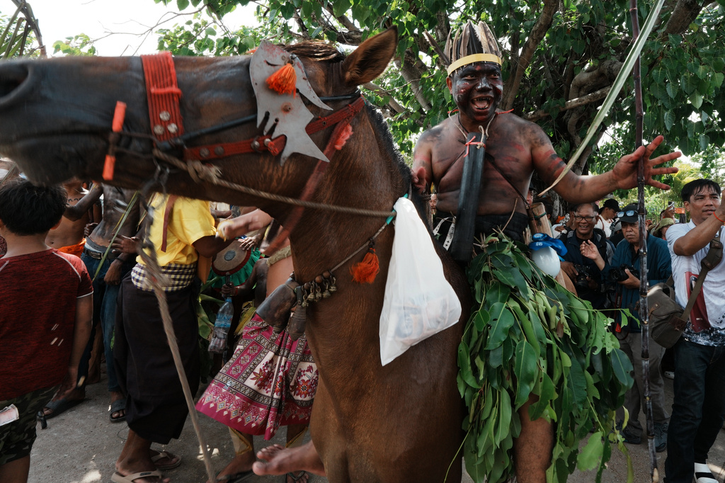 A man representing a ghost rides on a horse during a ceremony to invoke rain amid the rice planting season in Pring Ka-ek village, northwest of Phnom Penh, Cambodia, Thursday, May 21, 2026. (AP Photo/Heng Sinith)
