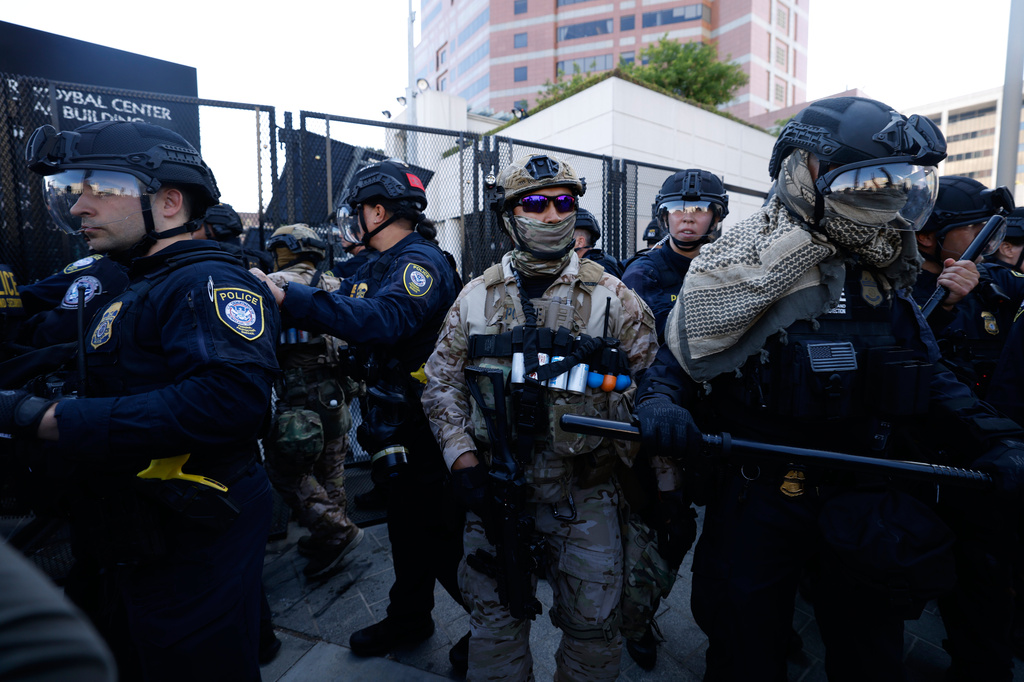 Protesters confront federal law enforcement agents outside the Metropolitan Detention Center on Saturday, June 6, 2026, commemorating federal immigration raids and community protests one year ago in Los Angeles. (AP Photo/Jill Connelly)