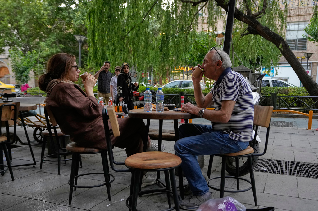 People drink coffee in the al fresco dining area of a cafe near the old main bazaar of Tehran, Iran, Thursday, May 28, 2026. (AP Photo/Vahid Salemi)