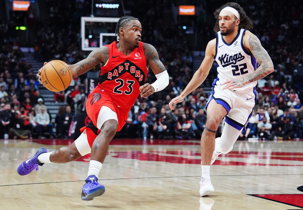 Toronto Raptors' Jamal Shead (23) drives past Sacramento Kings' Devin Carter (22) during the first half of an NBA basketball game in Toronto on Wednesday, April 1, 2026. (Frank Gunn/The Canadian Press via AP)
