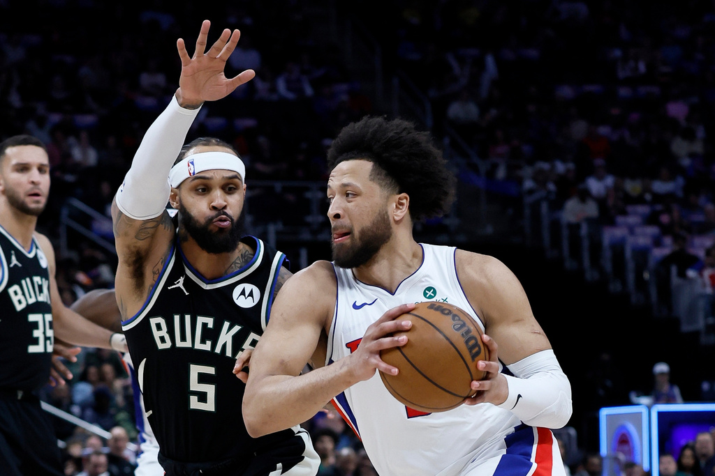 Detroit Pistons guard Cade Cunningham (2) drives against Milwaukee Bucks guard Gary Trent Jr. (5) during the first half of an NBA basketball game Wednesday, April 8, 2026, in Detroit. (AP Photo/Duane Burleson)