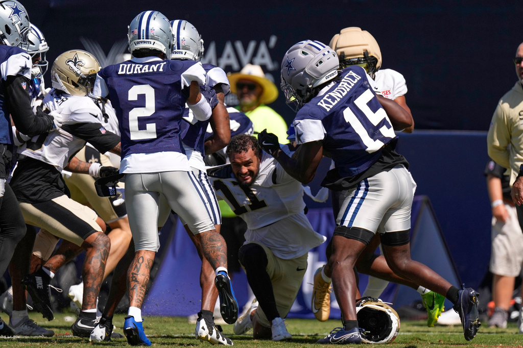 New Orleans Saints wide receiver Ronnie Bell, center, fights with members of the Dallas Cowboys, including safety Cobie Durant (2) and cornerback Derion Kendrick (15) during an NFL football joint practice, Tuesday, Aug. 18, 2026, in Oxnard, Calif. (AP Photo/Mark J. Terrill)
