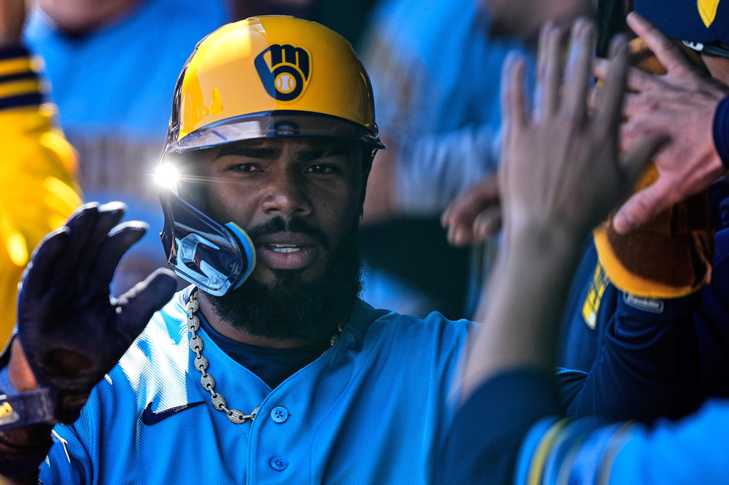Milwaukee Brewers' Luis Rengifo celebrates in the dugout after scoring on a double by Garrett Mitchell during the first inning in the first baseball game of a doubleheader against the Kansas City Royals, Saturday, April 4, 2026, in Kansas City, Mo. (AP Photo/Charlie Riedel)