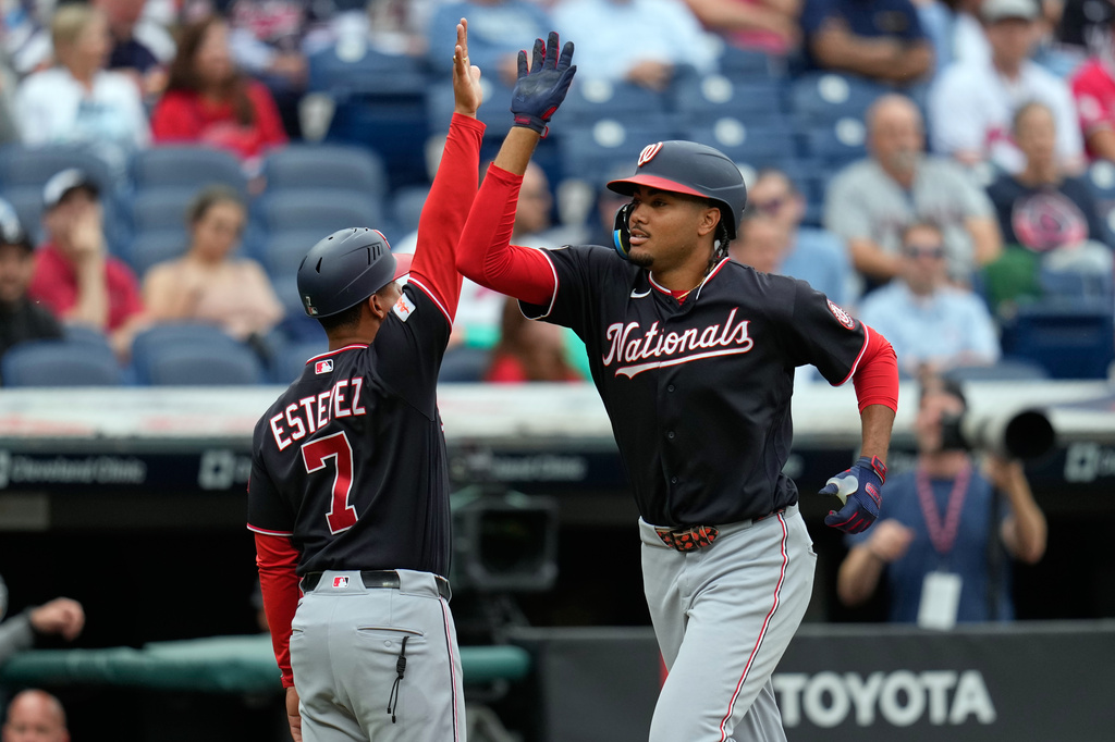 Washington Nationals' James Wood, right, gets a high five from third base coach Victor Estevez (7) as he runs the bases after hitting a home run in the second inning of a baseball game against the Cleveland Guardians in Cleveland, Tuesday, May 26, 2026. (AP Photo/Sue Ogrocki)