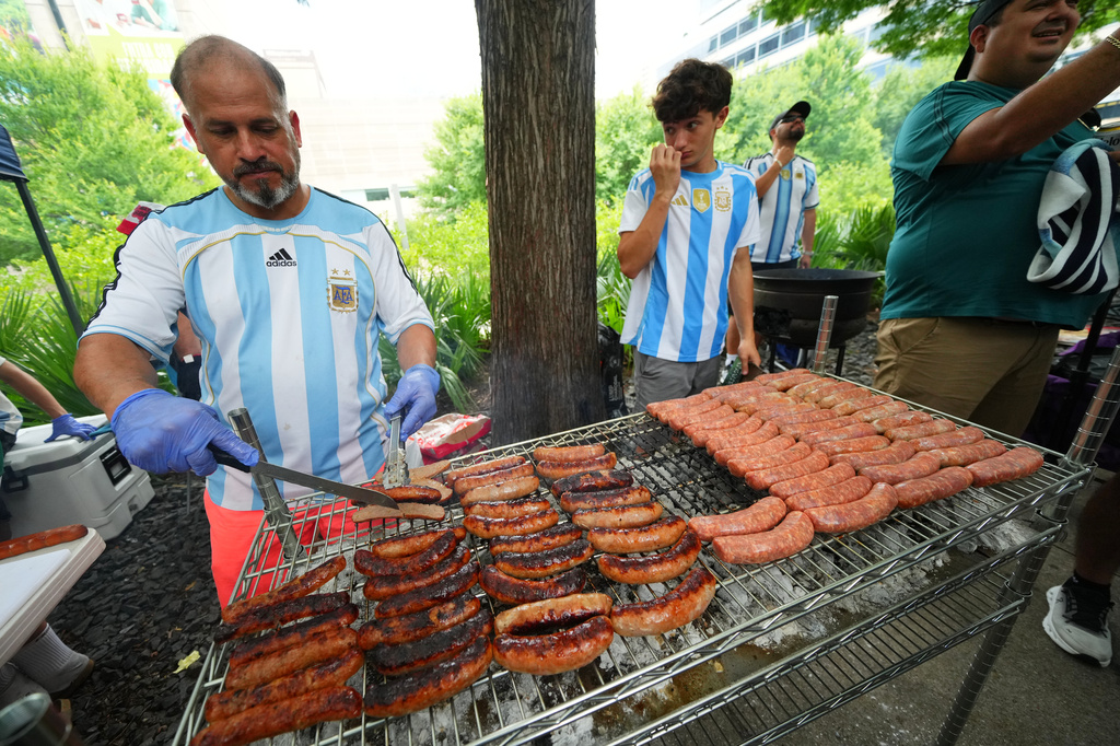 An Argentina supporter grills sausages during a rally ahead of his team's World Cup Group J soccer match against Austria, Sunday, June 21, 2026, in Dallas. (AP Photo/Julio Cortez)