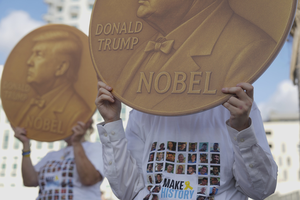 Demonstrators wear shirts with photos depicting the faces of Israeli hostages who are being held in the Gaza Strip, during a protest demanding their release, outside the U.S. Embassy Branch Office in Tel Aviv on Tuesday, Sept. 2, 2025. (AP Photo/Ariel Schalit)