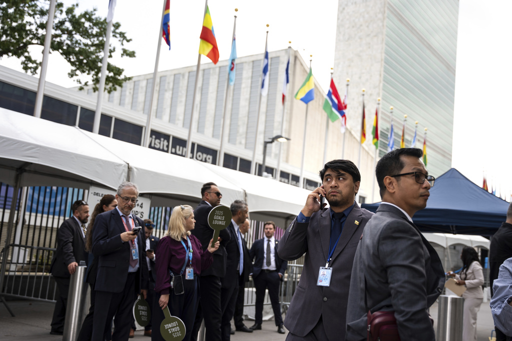 People stand outside the United Nations Headquarters on the first day of the 80th session of the U.N. General Assembly, Monday, Sept. 22, 2025. (AP Photo/Angelina Katsanis)