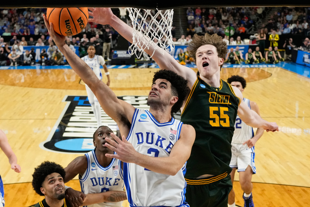Duke guard Cayden Boozer drives to the basket past Siena center Riley Mulvey during the second half in the first round of the NCAA college basketball tournament, Thursday, March 19, 2026, in Greenville, S.C. (AP Photo/Chris Carlson)