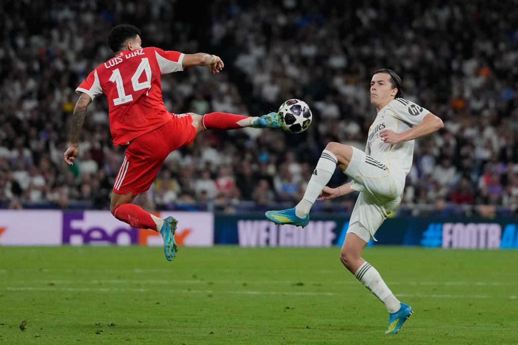Real Madrid's Alvaro Carreras, right, and Bayern's Luis Diaz challenge for the ball during the Champions League quarterfinal first leg soccer match between Real Madrid and Bayern Munich in Madrid, Spain, Tuesday, April 7, 2026. (AP Photo/Bernat Armangue)