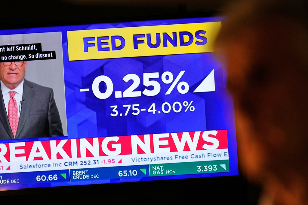 A TV displays news about the Federal Reserve as traders work on the floor at the New York Stock Exchange in New York, Wednesday, Oct. 29, 2025. (AP Photo/Seth Wenig)