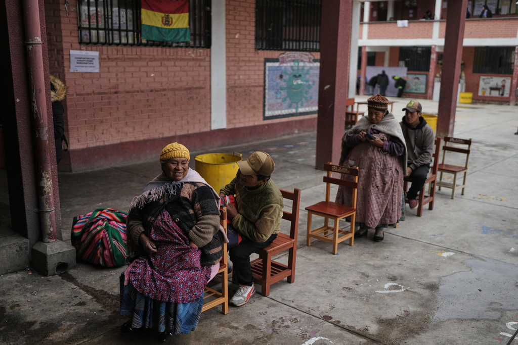 Voters wait their turn at a polling station during a presidential runoff election in El Alto, Bolivia, Sunday, Oct. 19, 2025. (AP Photo/Ivan Valencia)