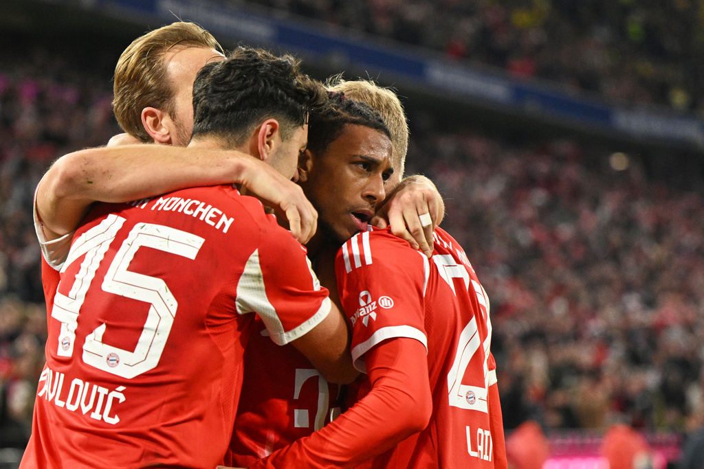 Bayern's Michael Olise, centre, celebrates with teammates after scoring his side's second goal during the Bundesliga soccer match between Bayern Munich and Borussia Dortmund in Munich, Germany, Saturday, Oct. 18, 2025. (AP Photo/Lennart Preiss)