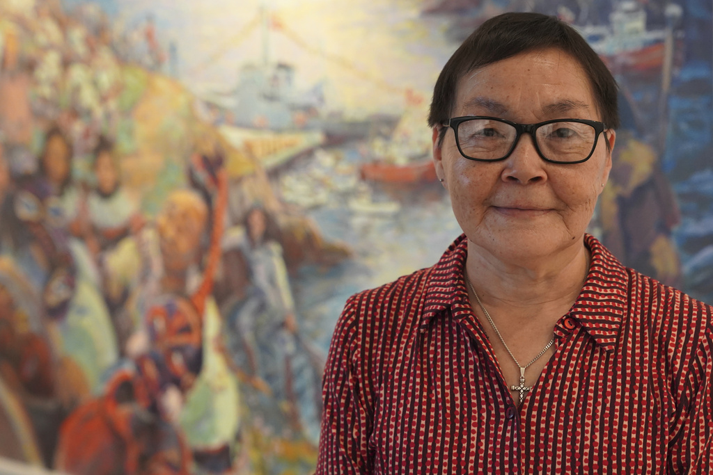 52-year-old retiree Katrine Petersen poses for a photo in front of a painting at The Greenlandic House in central Copenhagen, Denmark, Sept. 19, 2025. (AP Photo/James Brooks)
