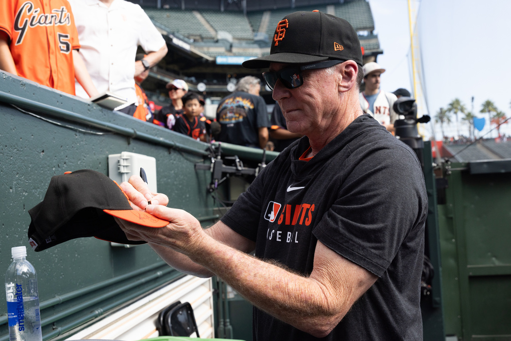 San Francisco Giants manager Bob Melvin gives out autographs before an MLB baseball game against the Colorado Rockies, Saturday, Sept. 27, 2025, in San Francisco. (AP Photo/Benjamin Fanjoy)
