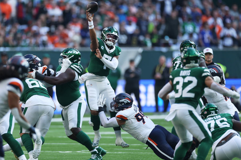New York Jets quarterback Justin Fields throws under pressure from Denver Broncos defensive end Zach Allen in the first half of an NFL football game Sunday, Oct. 12, 2025, in London. (AP Photo/Ian Walton)