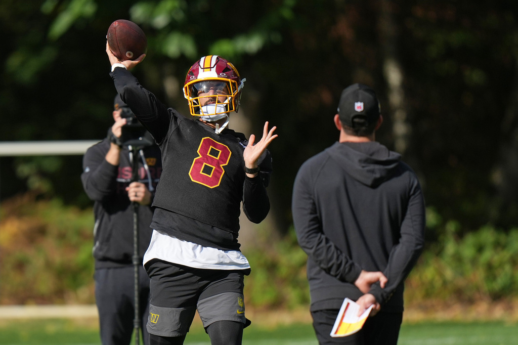 Washington Commanders' quarterback Marcus Mariota throws the ball during an NFL football practice in Hertfordshire, England, Friday, Oct. 2, 2026. (AP Photo/Alastair Grant)