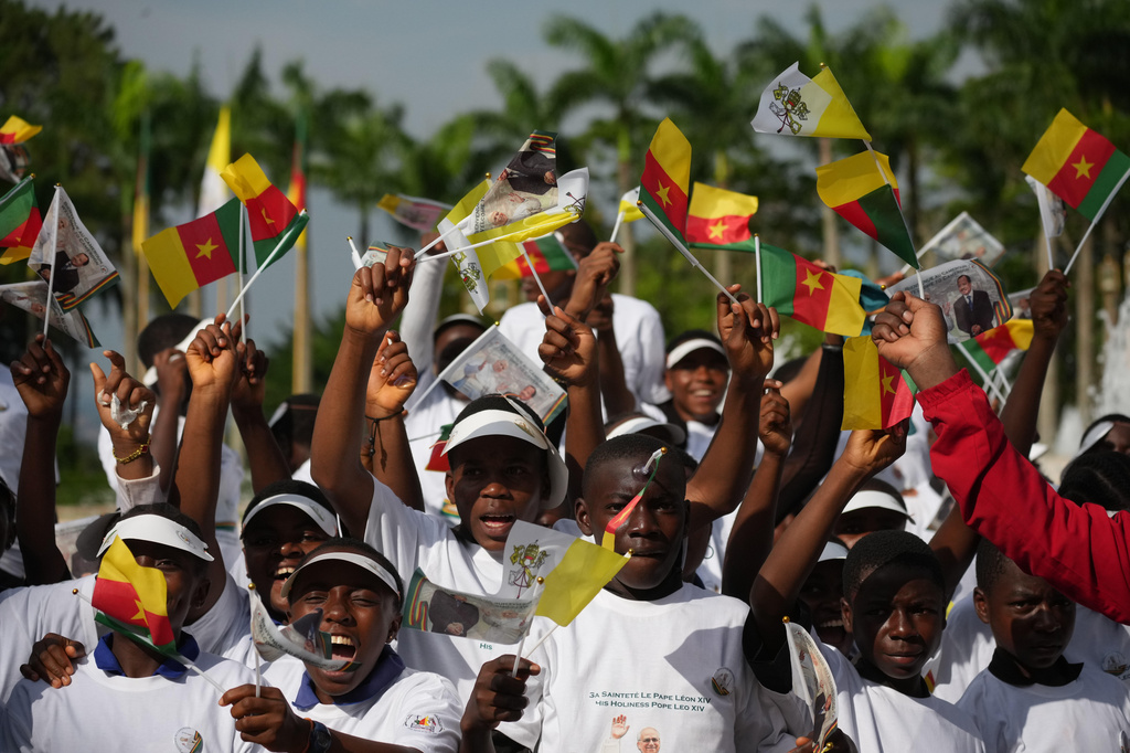 Children wave Cameroon and Vatican flags to greet Pope Leo XIV upon his arrival in Yaounde, Cameroon, Wednesday, April 15, 2026, on the third day of an 11-day apostolic journey to Africa. (AP Photo/Andrew Medichini)