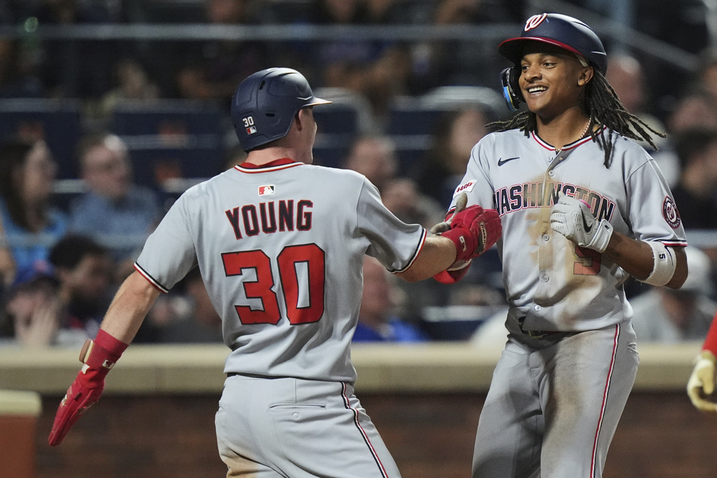 Washington Nationals' CJ Abrams, right, celebrates with Jacob Young after they score on a two-run home run during the fifth inning of a baseball game against the New York Mets Friday, Sept. 19, 2025, in New York. (AP Photo/Frank Franklin II)